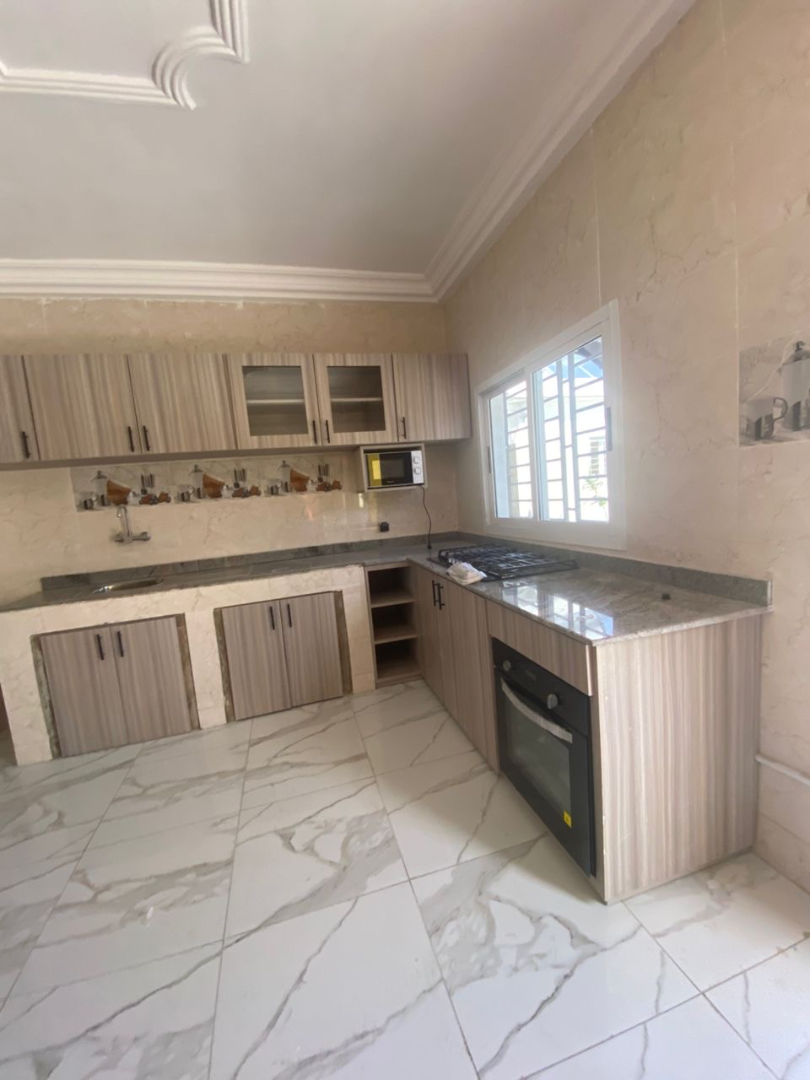 Cuisine moderne en L avec plan de travail granite et rangements sur mesure – Aménagement cuisine à Abidjan | GIC-Designs, vue 5