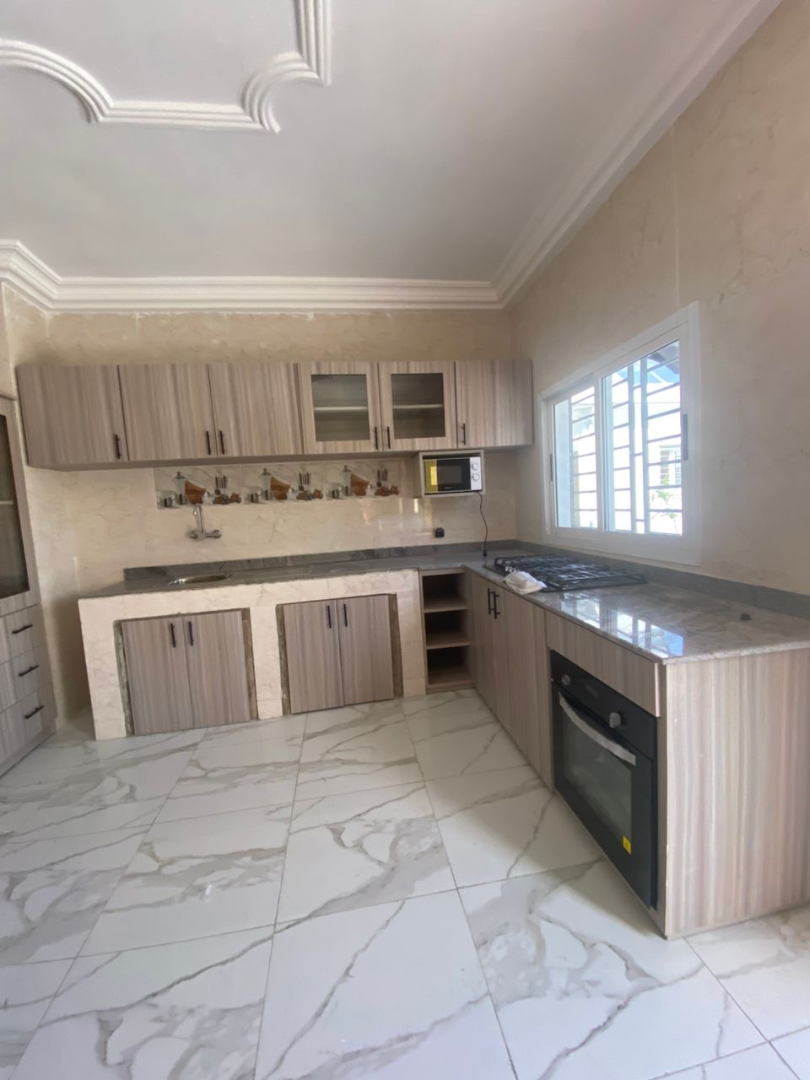 Cuisine moderne en L avec plan de travail granite et rangements sur mesure – Aménagement cuisine à Abidjan | GIC-Designs, vue 4