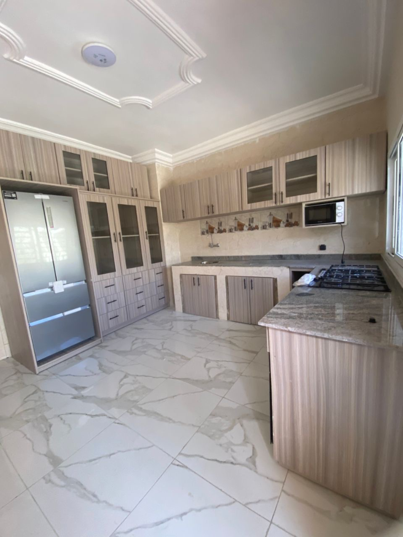 Cuisine moderne en L avec plan de travail granite et rangements sur mesure – Aménagement cuisine à Abidjan | GIC-Designs, vue 3